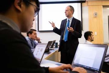 Bryant University Professor Peter Nigro instructs students inside a tiered classroom in the Unistructure.
