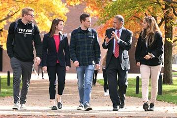 A group of students walk with Madan Annavarjula at Bryant University.