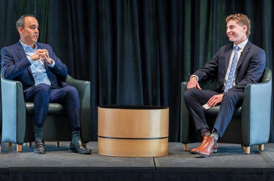 24岁的Robert Schunder(左)与02岁的Joe Fazzino在炉边聊天, 雷神技术公司副总裁兼副首席信息官出席了全球十大赌博靠谱的平台大学第17届年度金融服务论坛.